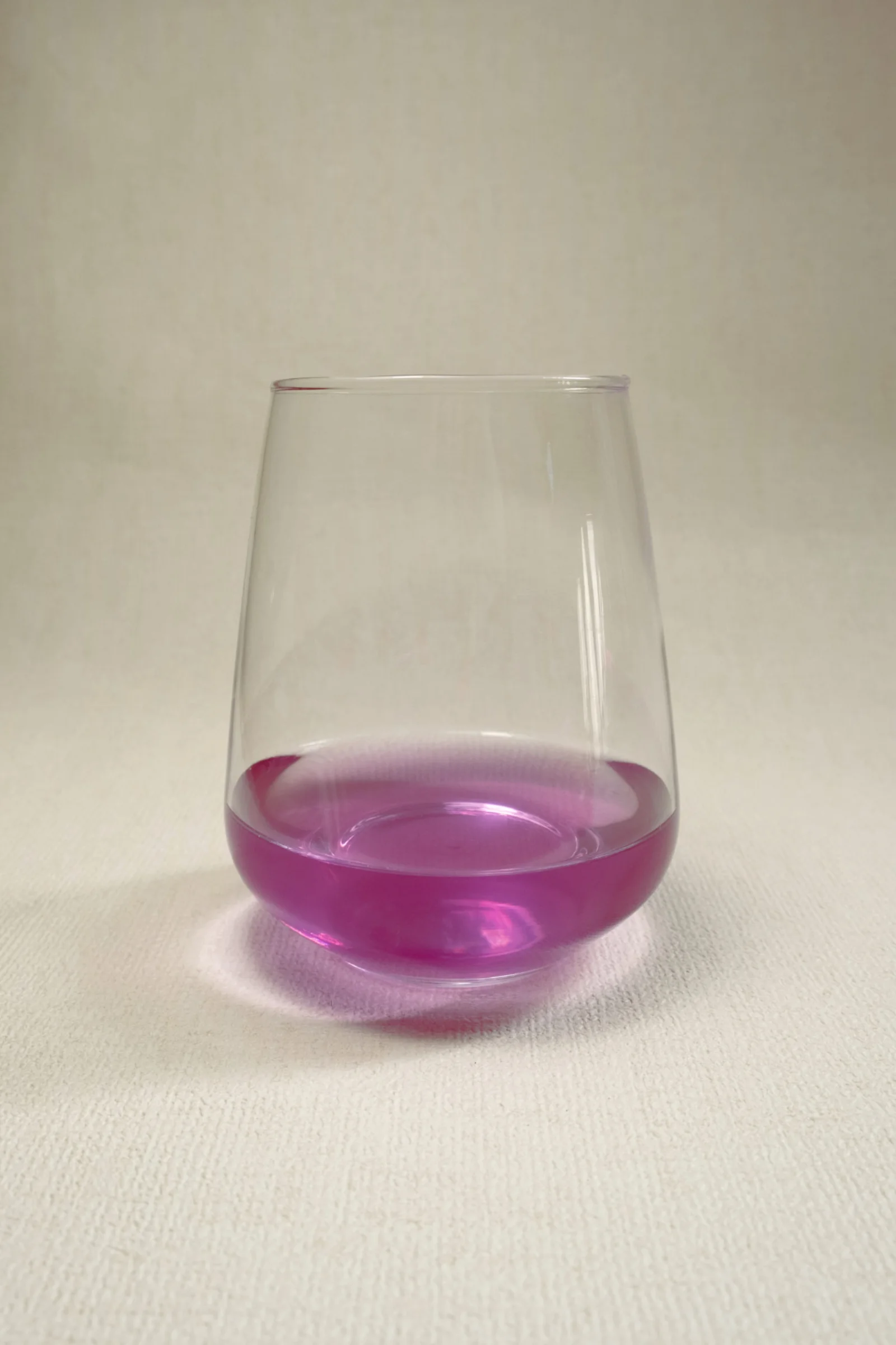 Vivid purple-pink ube extract in a clear glass, the natural anthocyanin colour that artificial ube flavouring imitates